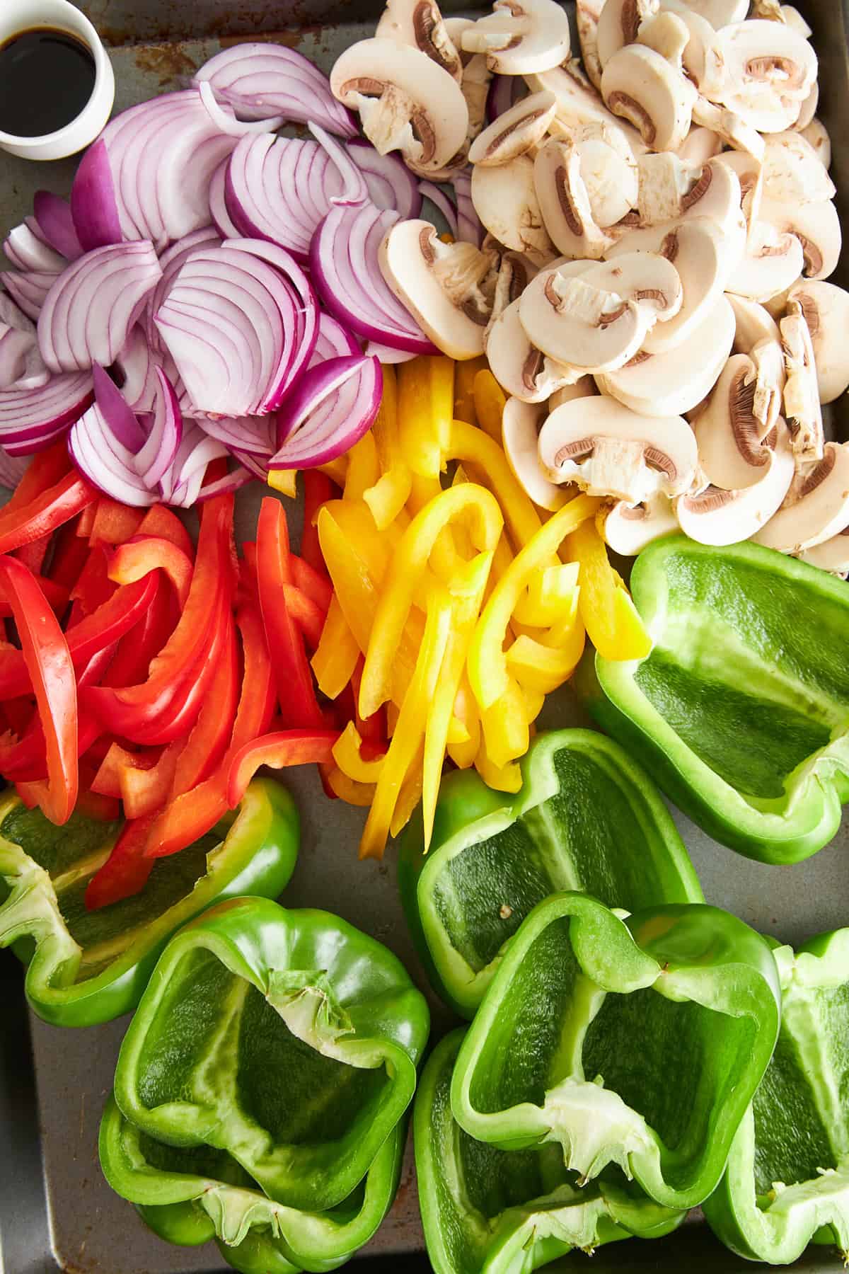 Sliced bell peppers, green bell pepper halves, mushrooms, and red onions. 