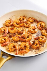 Blackened shrimp in a skillet.