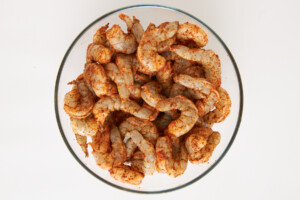 Raw seasoned shrimp in a mixing bowl.