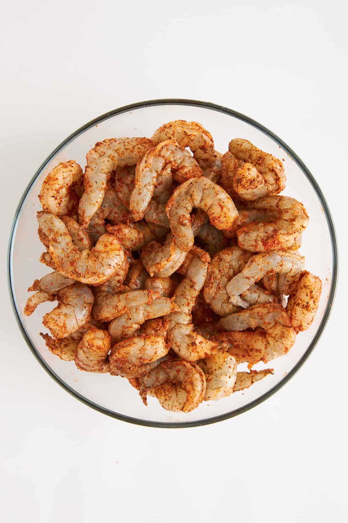 Raw seasoned shrimp in a bowl. 