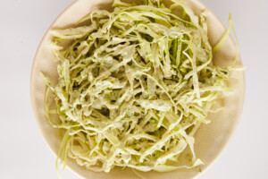 Homemade cabbage slaw in a mixing bowl.