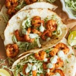 Three blackened shrimp tacos with slaw.