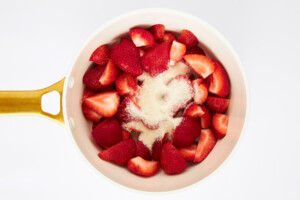 Sugar and strawberries in a saucepan.