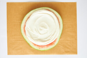 Yogurt spread over a watermelon round.