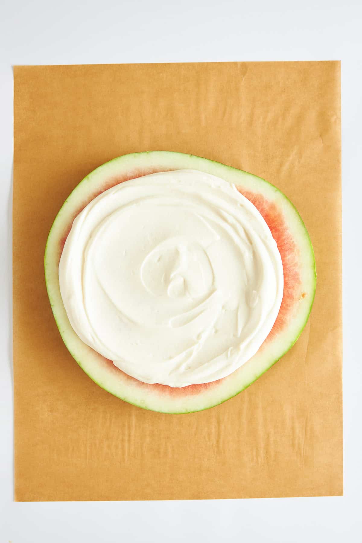 A watermelon round topped with yogurt. 