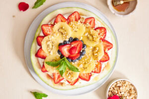 Watermelon pizza topped with granola and mint.