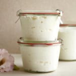 Two glass Weck jars full of homemade Greek yogurt stacked on top of each other.