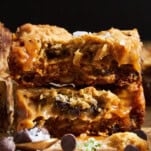 Side view of two stacked chocolate chip caramel bars.