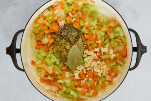 Onion, garlic, celery, and carrots sautéing in a stock pot.