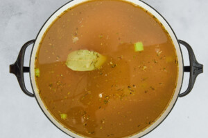 Chicken noodle soup ingredients simmering in a pot.