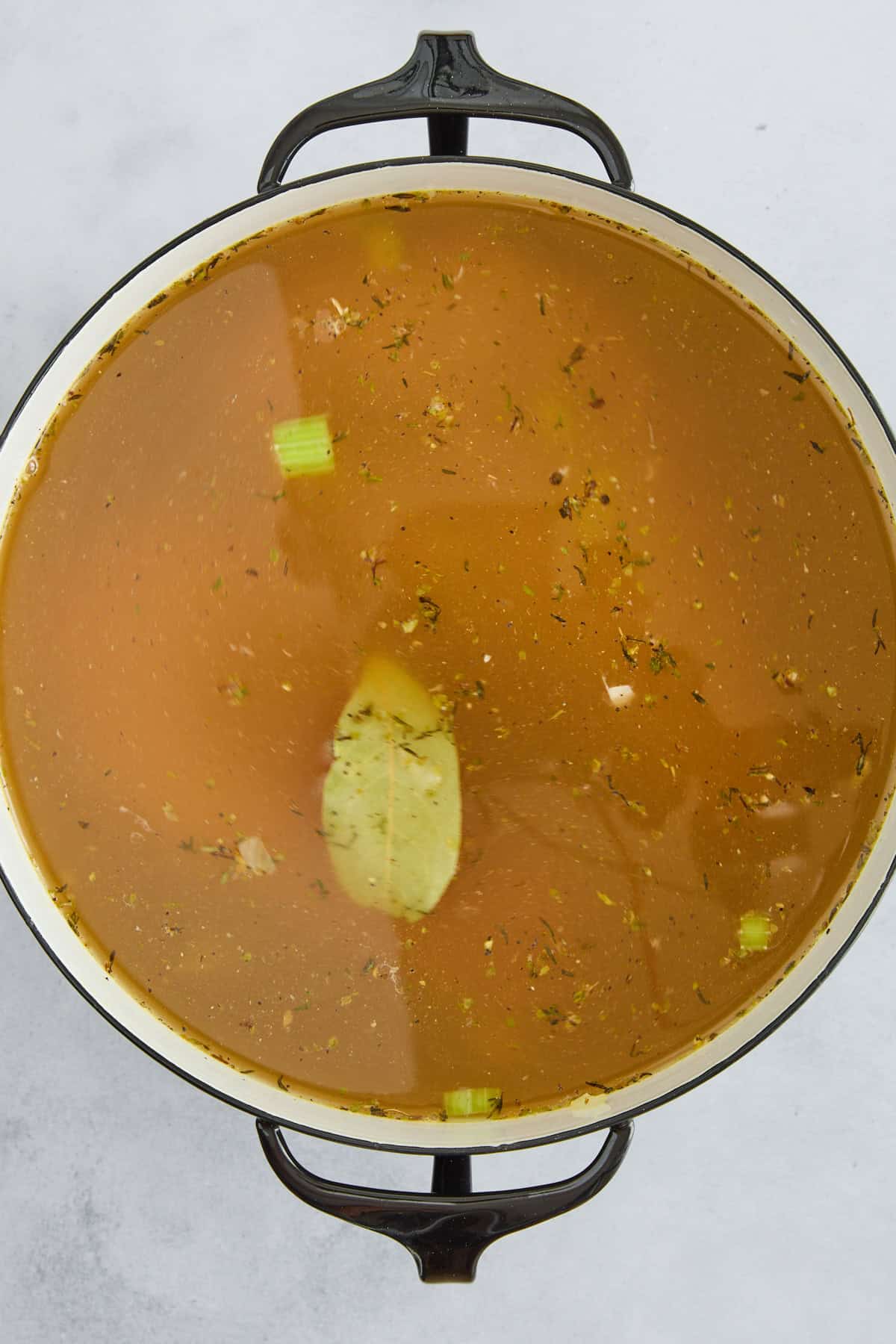 Chicken noodle soup ingredients simmering in broth. 