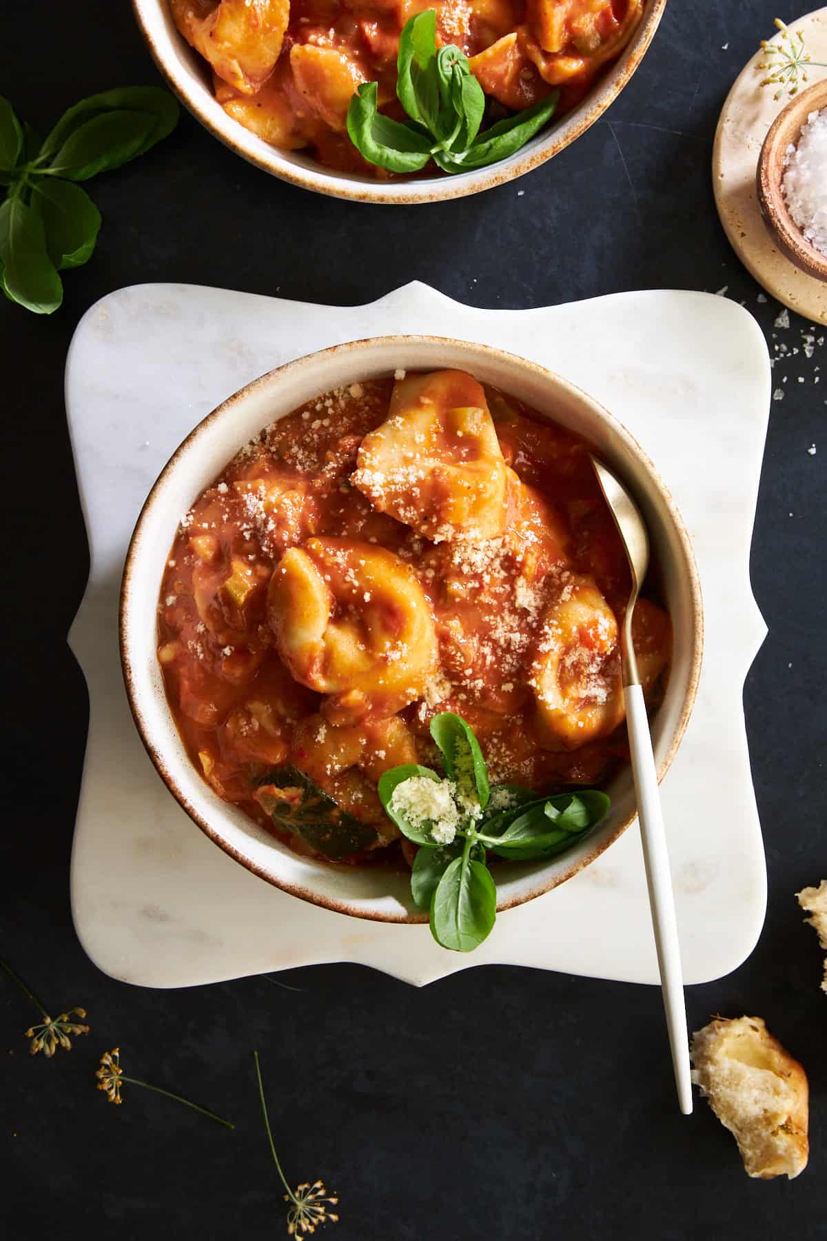 Overhead image of a bowl of cheese tortellini soup.