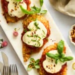 Three pieces of baked chicken parmesan on a platter.