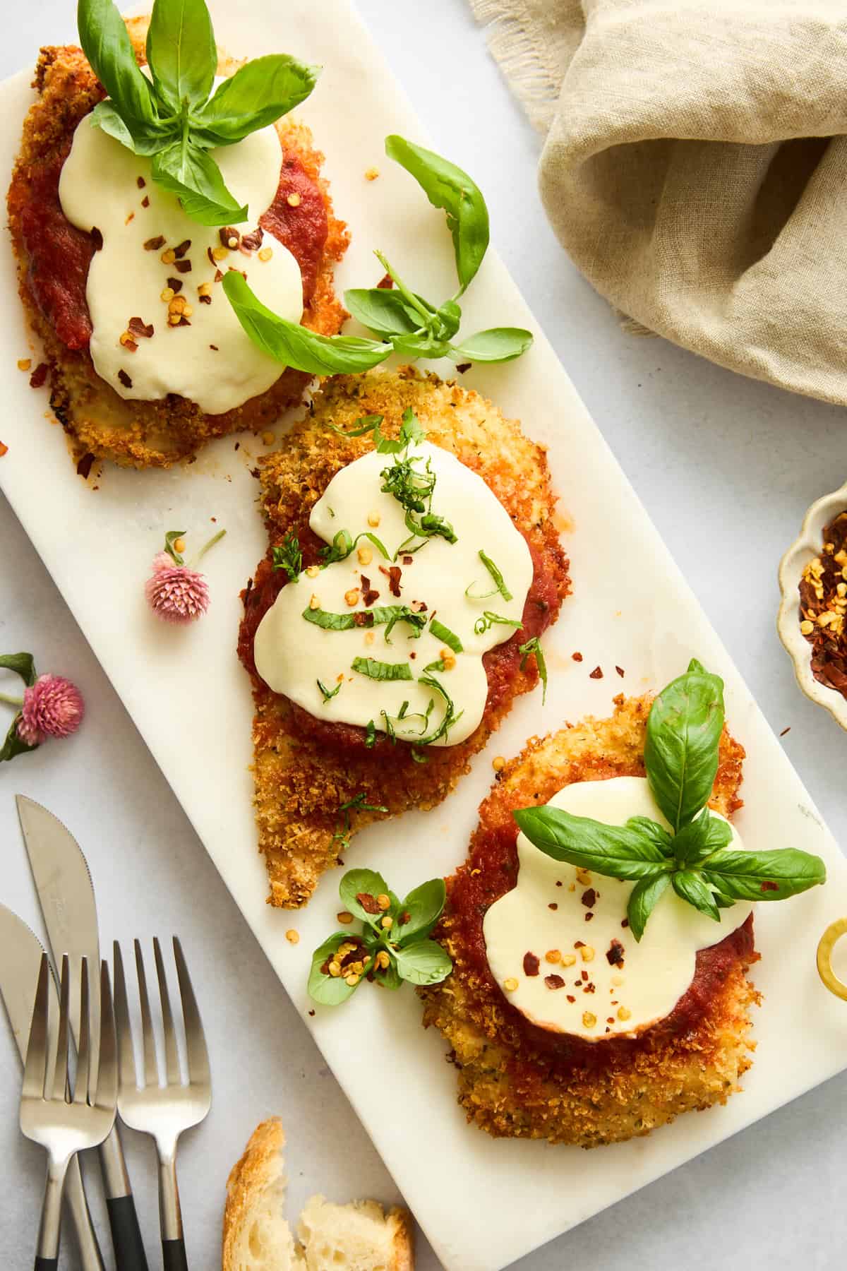 Baked chicken parmesan pieces on a platter. 