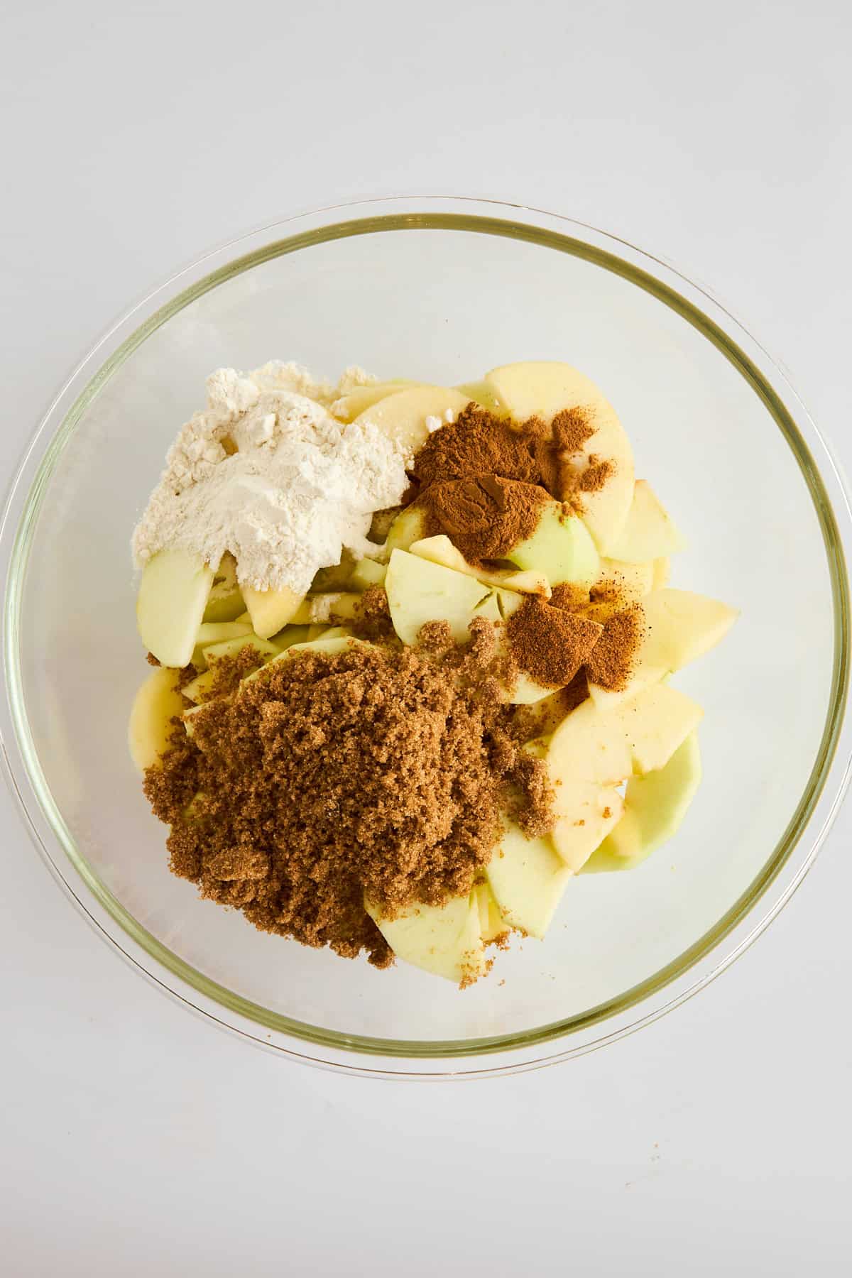 Sliced apples and spices in a bowl. 