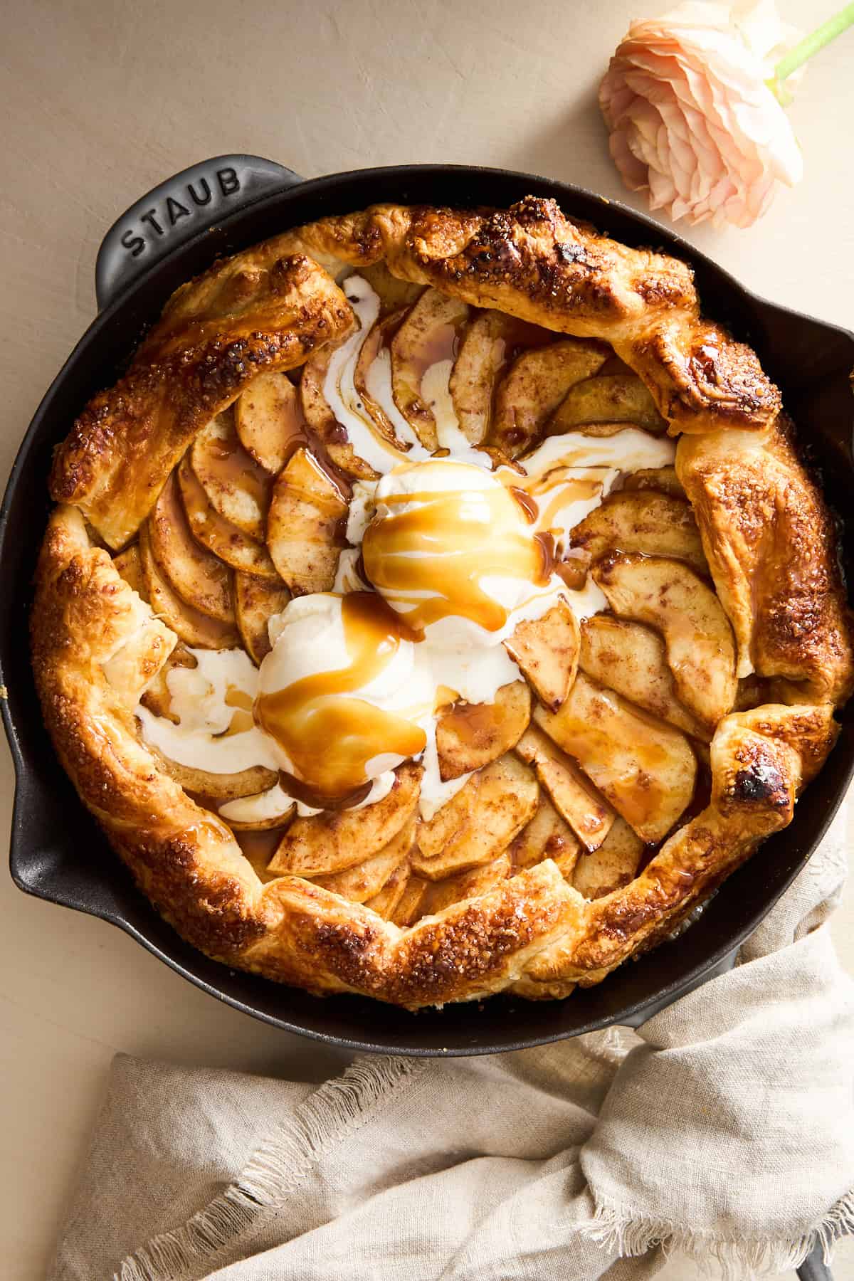 An apple galette topped with ice cream and caramel.