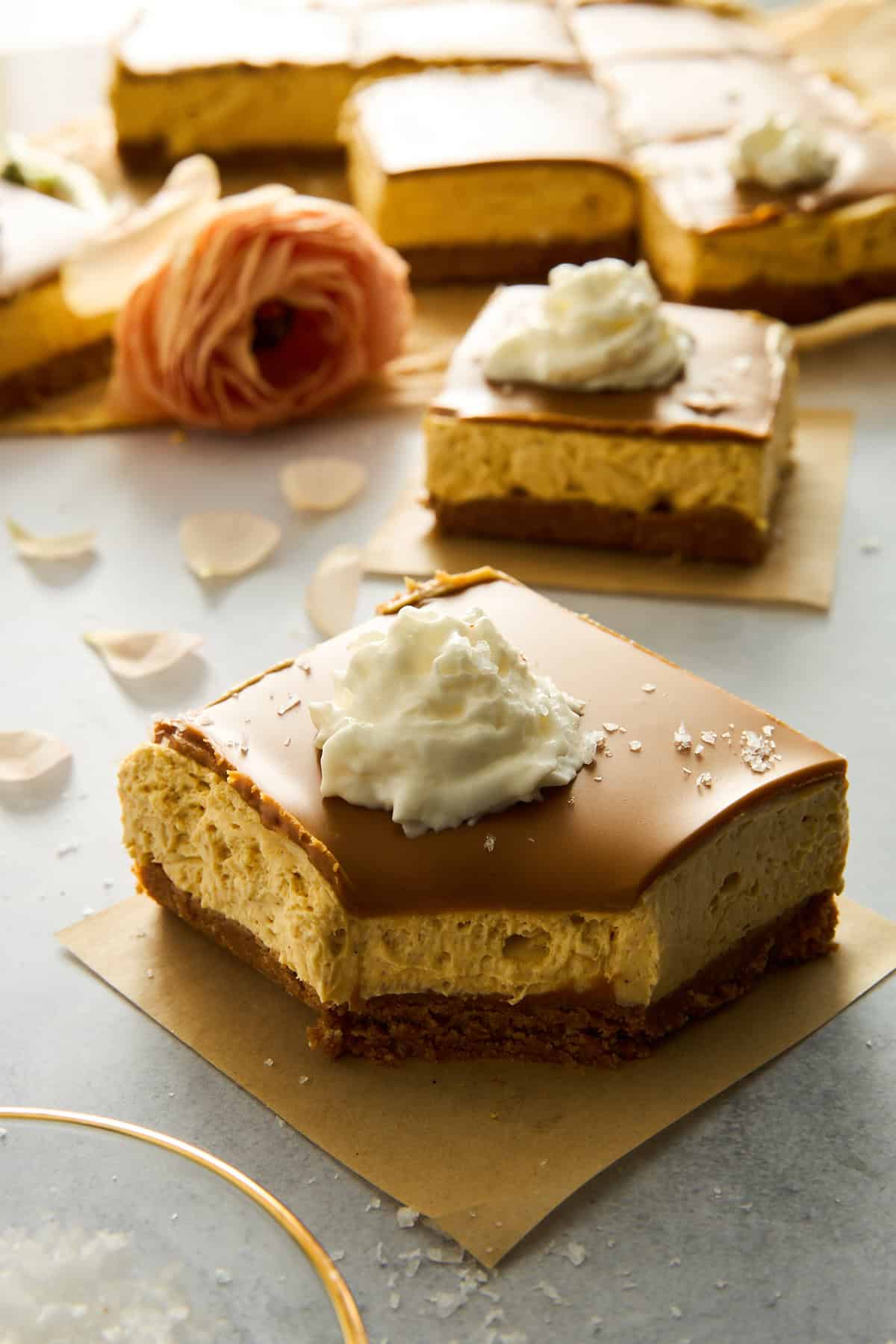 No-bake pumpkin cheesecake bars topped with whipped cream. 