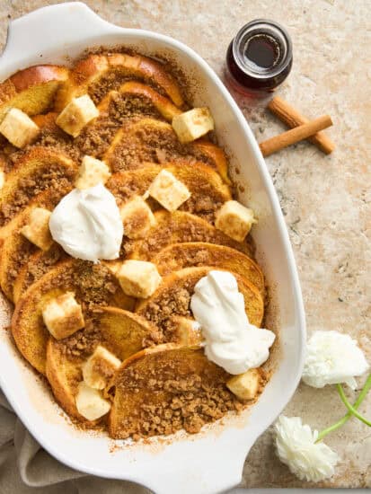 Maple french toast in a baking dish topped with yogurt and butter.