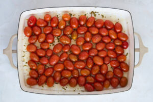 Seasoned cherry tomatoes in a baking dish.