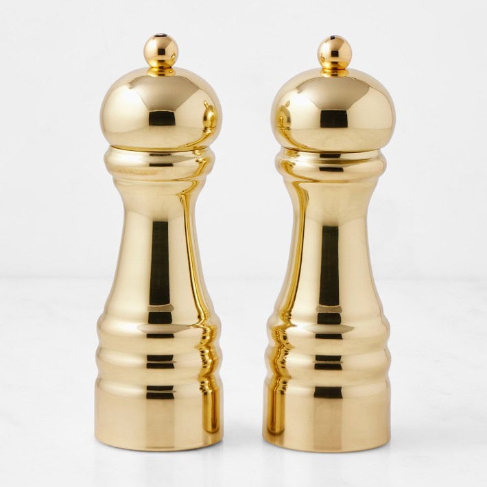 A pair of shiny gold salt and pepper mills.