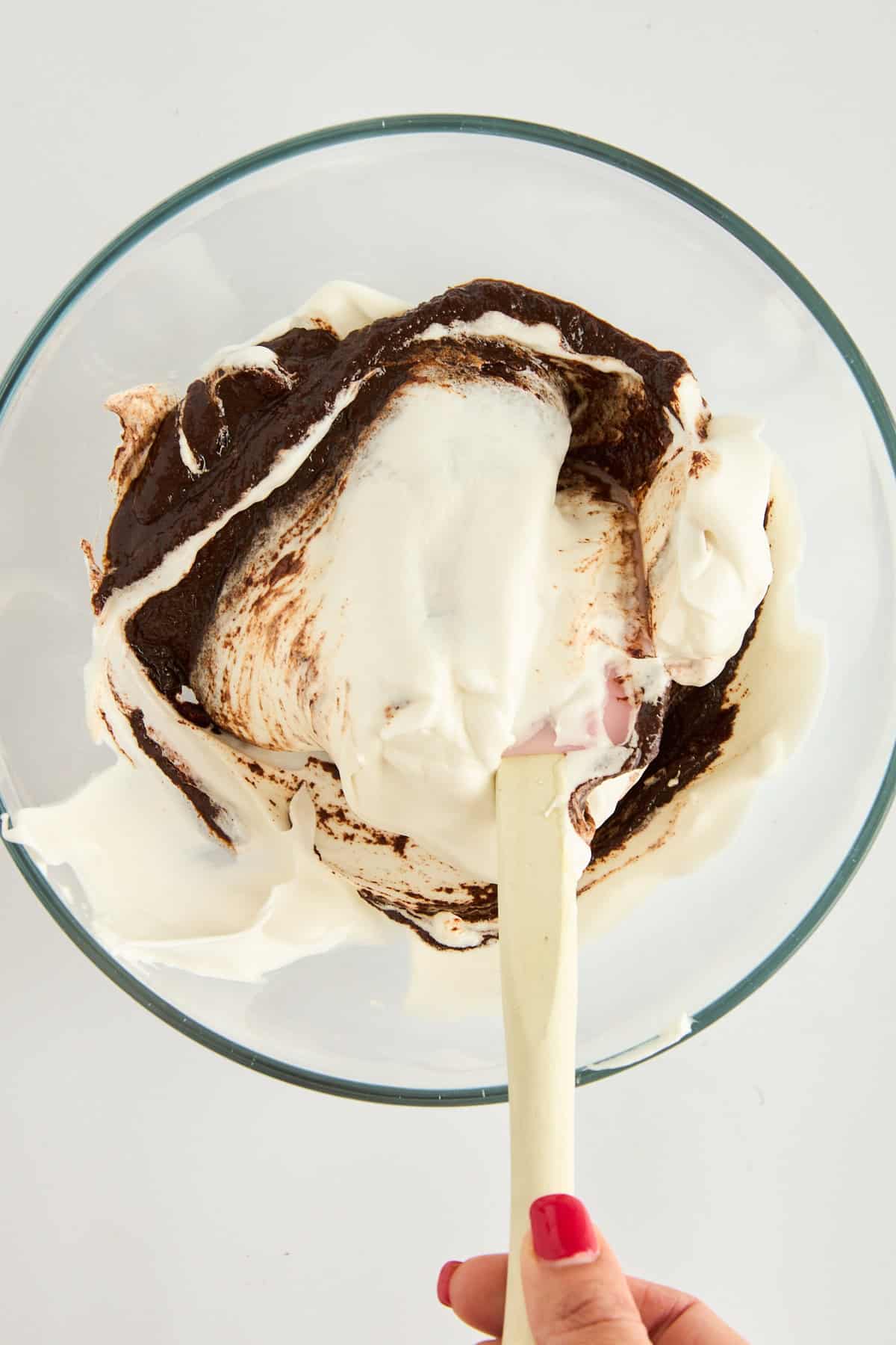 Melted chocolate and whipped egg whites being folded together. 