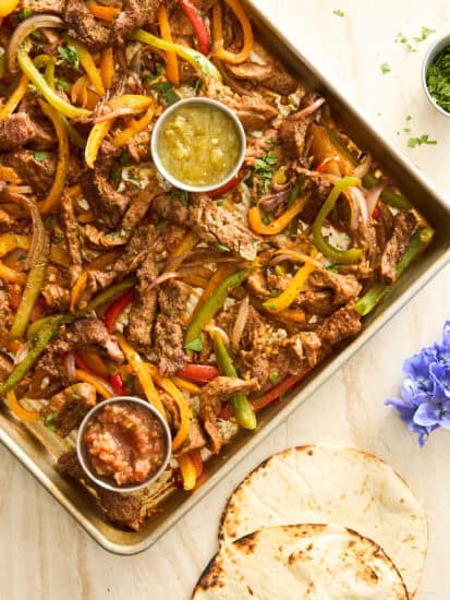 Sheet pan steak fajitas on a baking sheet.