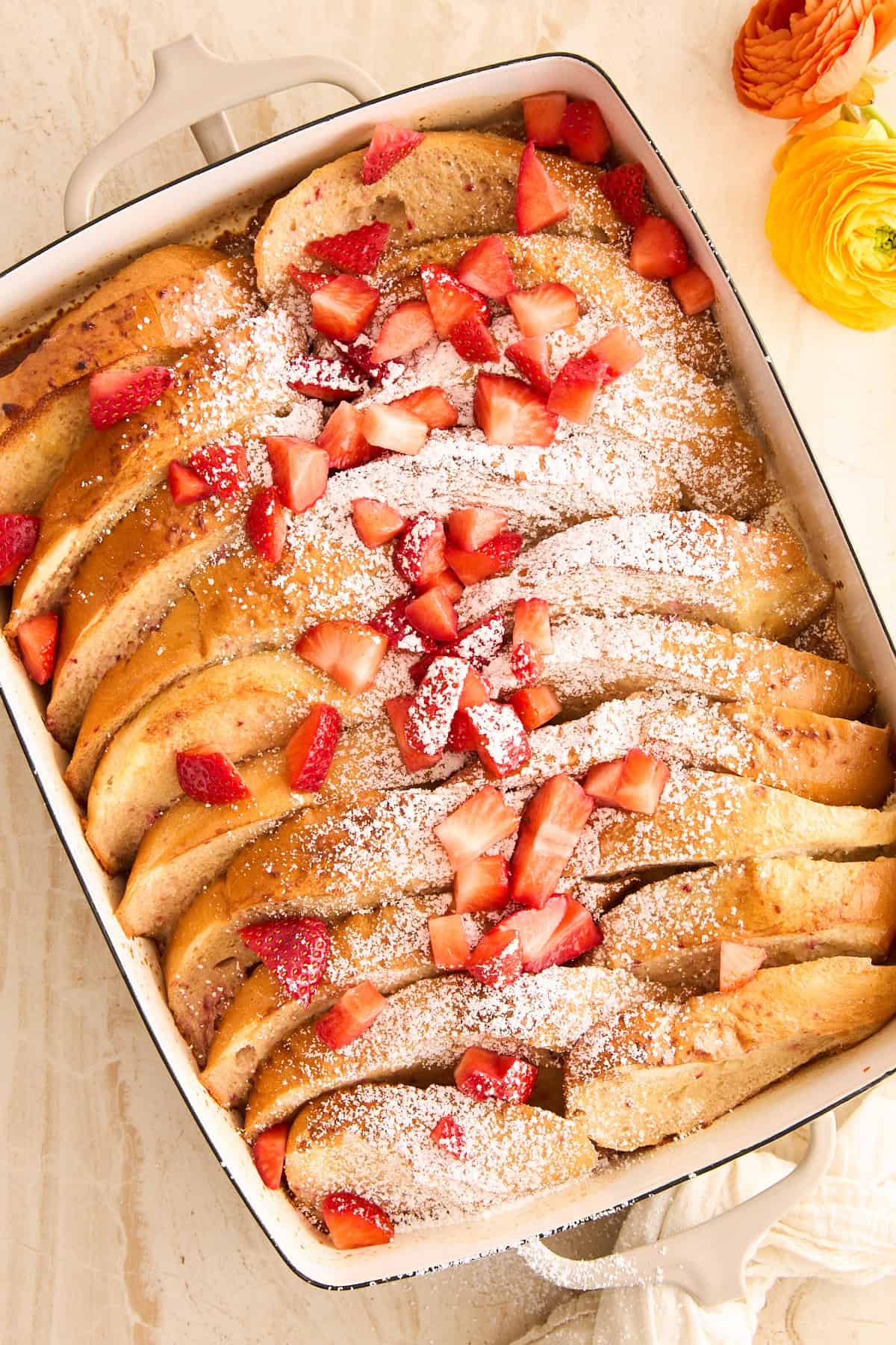 A baking dish full of whole pieces of strawberry french toast.