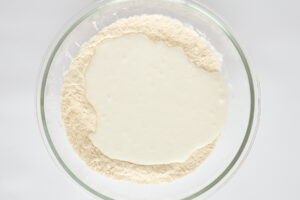 Flour and blended cottage cheese in a bowl.