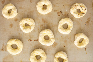 Unbaked cottage cheese bagels on a baking sheet.